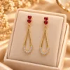 Red heart drop earrings with clear stones and polished gold tone finish
