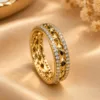 Dazzling gold tone crystal ring with wavy band and clear sparkling stones