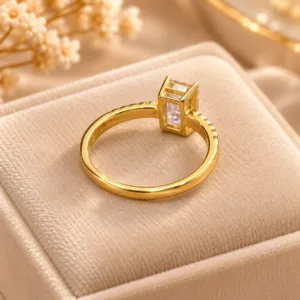Pink stone gold tone ring with rectangular center stone and sparkling side stones