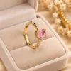 Pink stone gold tone ring with rectangular center stone and sparkling side stones