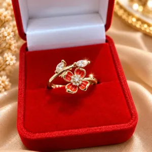 Gold tone flower ring with red enamel petals and clear sparkling stones