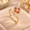 Gold tone flower ring with red enamel petals and clear sparkling stones