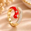 Red enamel gold tone ring with sparkling clear stones
