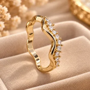 Stunning gold tone crystal ring with wavy band and clear sparkling stones