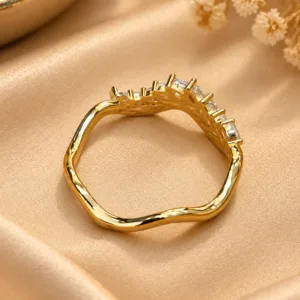 Stunning gold tone crystal ring with wavy band and clear sparkling stones