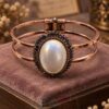 Vintage Copper Tone Oval Cabochon Metal Bracelet with dark halo stones