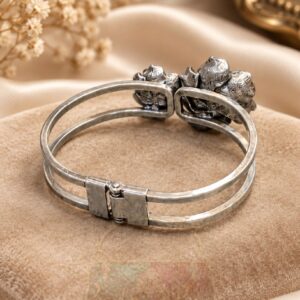 featuring two sculpted flowers, engraved petals, luminous pearl-style centres and a hinged double band.